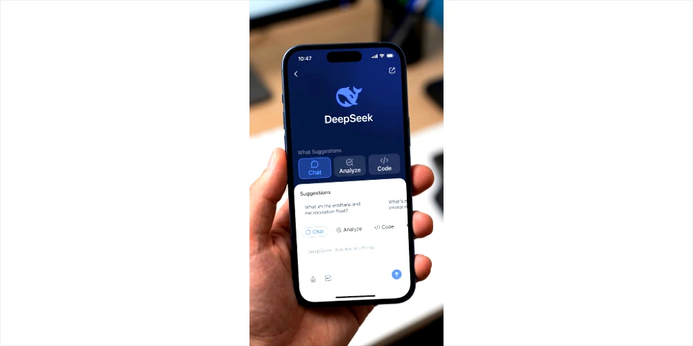 A focused, close-up photograph of a smartphone screen displaying the main interface of the DeepSeek AI application. The app features a clean design with dark navy blue headers and white text, centered around a blue stylized dolphin logo, below which is the 'DeepSeek' title. The user is on the 'Chat' tab, with suggestions like 'Chat', 'Analyze', and 'Code' visible.